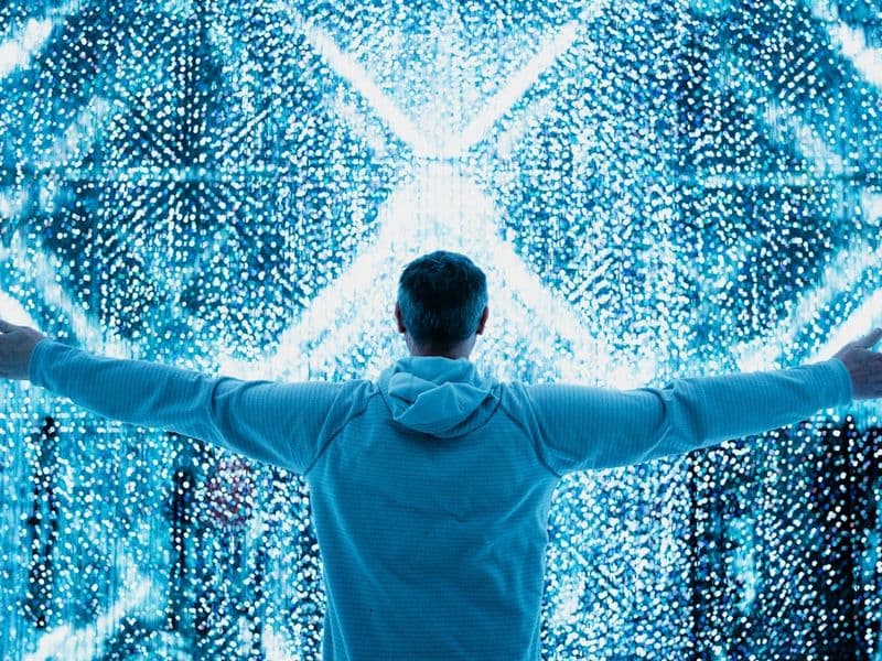 Homem em frente a grande monitor com dashboard de dados de saúde e tecnologia